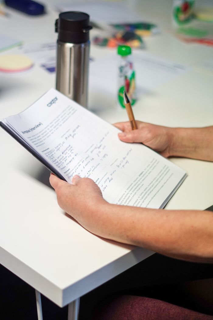 A close-up shot of a person's hand holding documents on a desk, useful for business themes.